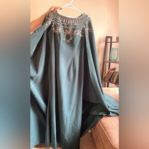 Green dress with cape attached to the back.